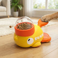 Jeu-intelligent-pour-chien-chiot-interactif, en forme de canard original avec pédale pour libérer les croquettes ou le friandises , jouet distributeur de croquettes avec rotation pour stimuler l'intelligence du chien, et un effet anti-glouton qui ralenti la prise d'alimentation,jouet éducatif et d'occupation pour le chiot et le chien adulte-gros plan sur la patte d'un chien adulte qui appuie sur le pédale du jouet canard ou les croquettes tourne dans son hublot transparent et une croquette qui sort du trou
