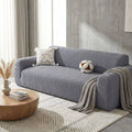 Protection-canape-antiderapant-4-saisons, extensible, lavabkle en machine avec relief doux et sécurisant , tissu anti poils et résistant aux griffes, idéal pour les propriétaire de chiens, 4 tailles disponible du fauteuil 1 places au XL pour canapé 4 places-gros plan sur la protection de canapé gris qui protège le canapé 3 places du salon de l'appartement