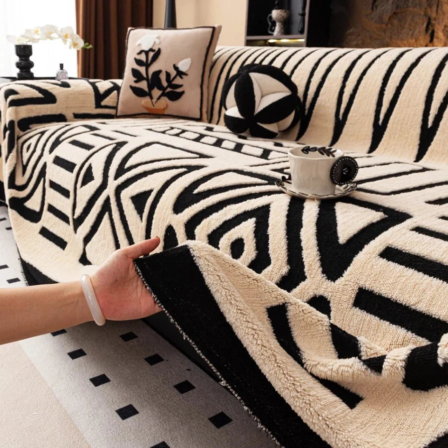 Protection-canape-chien-chiot-plaid chaud et épais, antidérapant et coutures solides, lavable en machine à laver avec design déométrique moderne pour couvrir et protéger le canapé, lit ou mobilier des poils et tâches des chiens, écoresponsable et résistantes aux griffes-gros plan sur la protection canapé chien de couleur blanc cassé et motif noir sur le canapé du salon 