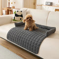 Protege-canape-chien-chiot-imperméable, résistant aux griffes, durable, tapis ou couverture qui protège des accidents, humidité saleté, boue,tissu anti poils, lavable en machine avec traversin en U pour un sentiment d'enveloppement ou un soutien du cou ou de la tête du chien, antidérapant pour chien de 0 à 15 kilos-un chiot en apprentissage de propreté sur le protege canape de couleur gris au rembourrage 100% coton sur le canapé du salon ouvert