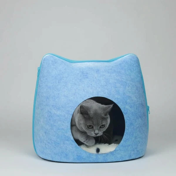 Cocon feutre pour chat bleu clair en forme de tête de chat avec un chat gris à l'intérieur