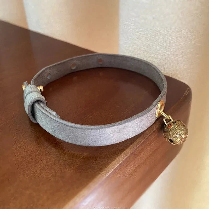 Collier à clochette pour chat Oscar et Plume en simili cuir gris avec une clochette dorée