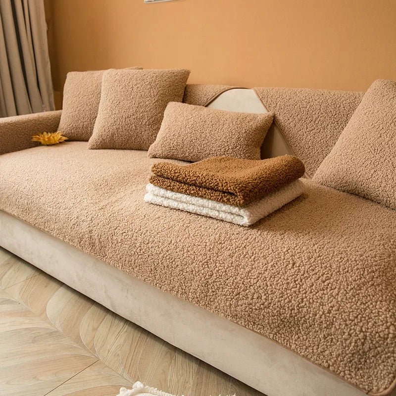 Couverture protection canapé beige en tissu pelucheux avec coussins assortis pour salon cosy