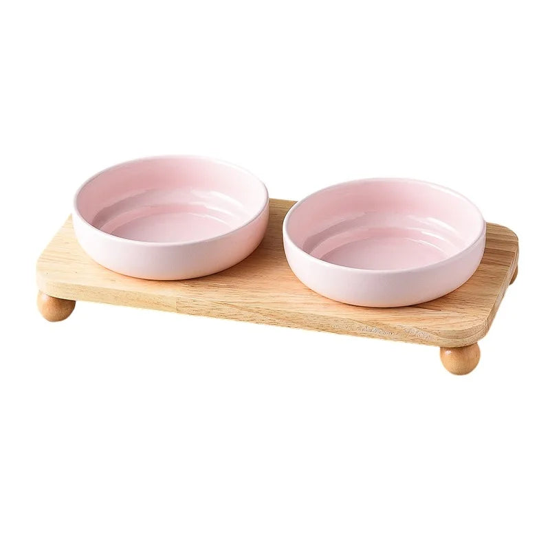 Gamelle céramique pour chien et chat avec deux bols roses sur un support en bois naturel