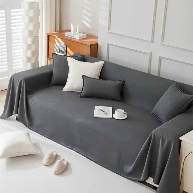 Couverture de protection canapé grise sur un canapé avec des coussins élégants pour un intérieur moderne