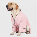 Chien Labrador portant un peignoir confortable pour chien rose avec boutons et finition noire