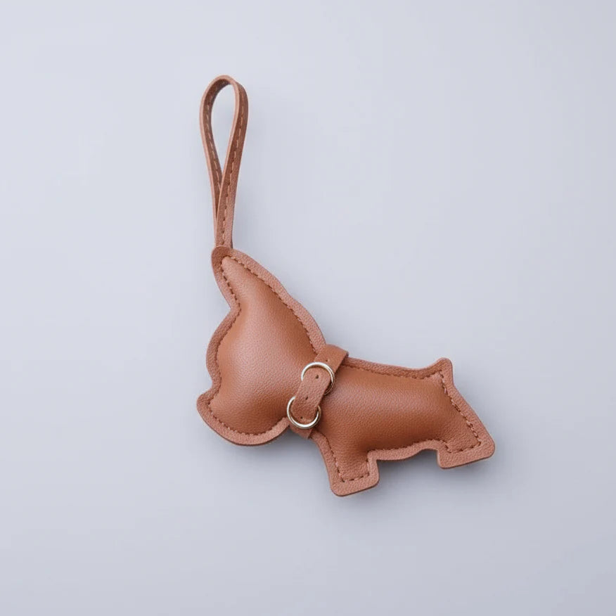 Porte clés bouledogue en cuir marron avec un design amusant tenant dans une main