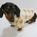 Sweat polaire pour teckel en beige à carreaux porté par un chien teckel noir et feu